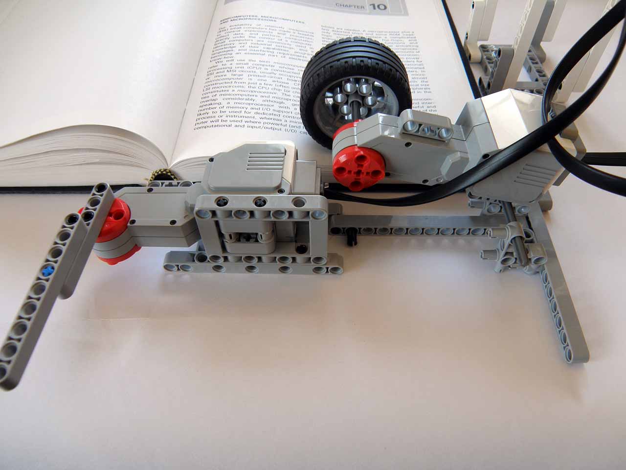 Close-up of the LEGO motor arm and wheel page-turning mechanism